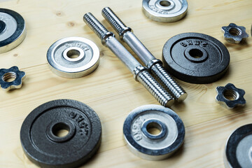 disassembled dumbbells on a wooden background