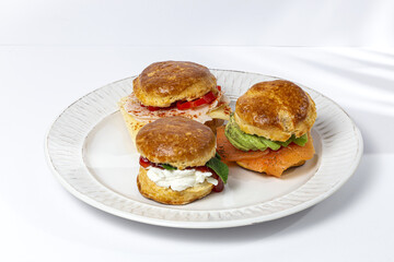 Assortment of homemade scones with ham, cheese, avocado, salmon, cream cheese and strawberry jam