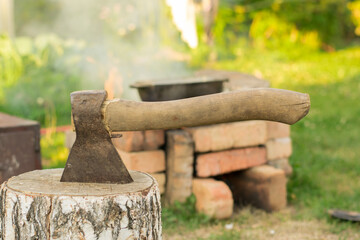 Old ax against a background of green grass. Cleaver.