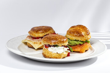 Assortment of homemade scones with ham, cheese, avocado, salmon, cream cheese and strawberry jam