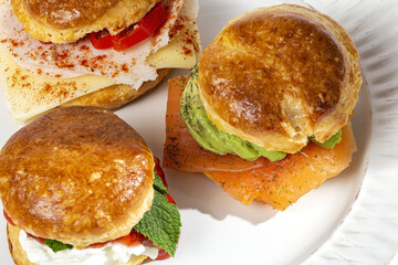 Assortment of homemade scones with ham, cheese, avocado, salmon, cream cheese and strawberry jam