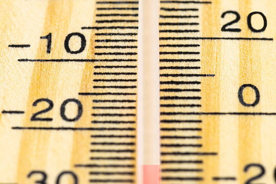A macro shot of a classic wooden thermometer showing a temperature -25 degrees Celsius, -13 degrees Fahrenheit.