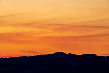 Sonnenuntergang mit Wald und Hügellandschaft
