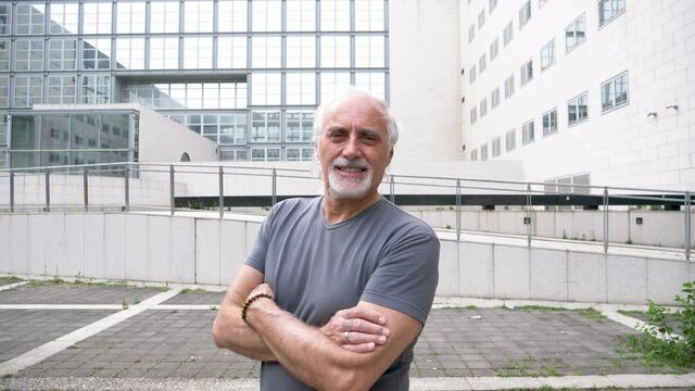 Slow motion shot of smiling senior athletic man with arms crossed