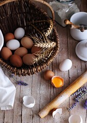 Fresh farmer eggs in a vintage basket on a rustic wooden table