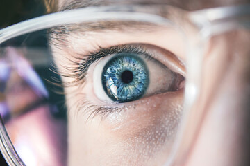 Close up of blue human eye with glasses. Reflection in glasses. Ophthalmology concept. Man with...
