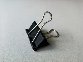Fototapeta premium Flexible steel office paper clip, placed on a gray background