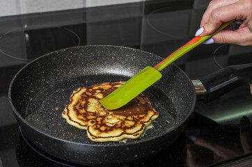 Cook fries pancakes in a pan on an induction cooker	
