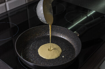 Cook fries pancakes in a pan on an induction cooker	
