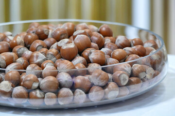 Bunch of hazelnuts in a glass bowl close up view