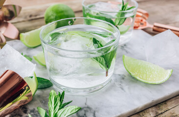 Lemonade, infused water or Mojito cocktail making. Mint, lime, ice ingredients and bar utensils.