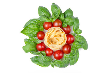 Pasta, cherry tomatoes and basil leaves on a white isolated background. Gamedients for dinner. Flat lay. Сopy space.