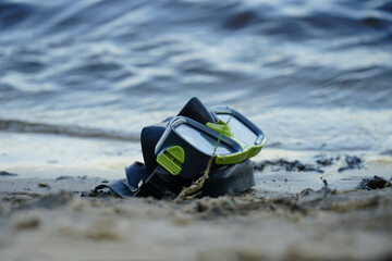 mask for diving lies on the sand, the shore against the background of the wave