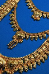 Oriental jewelry isolated on a blue background. with the image of a heart a symbol of love. Valentine's day gift
Arabic, Indian, Moroccan gold. 
