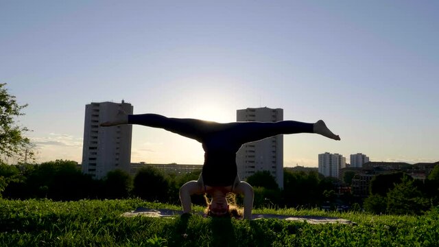 Young woman doing a handstand on viewpoint