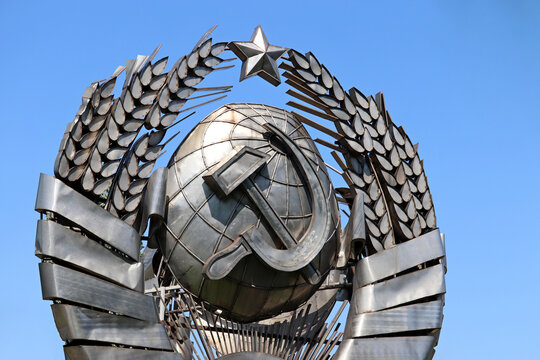 USSR coat of arms, communist and socialist symbol. Metal soviet emblem on blue sky background