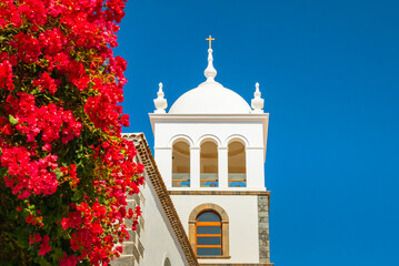 Old church Ex-Convento de San Francisco in Garachico and vibrant red flowers, Tenerife, Spain.