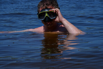 A guy in a diving mask dives out of the water