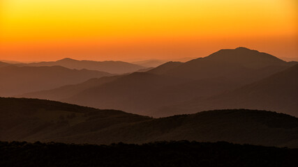 Silhouettes of mountains against the backdrop of the setting sun. Wielka Rawka Mountain. The Bieszczady Mountains, Carpathians. Poland