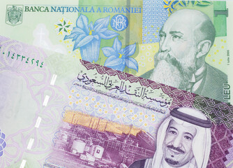 A close up image of a one Romanian leu bank note with a colorful five riyal Saudi Arabian bank note in macro
