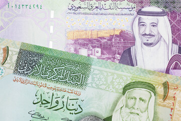 A colorful five Saudi riyal bank note with a one dinar bill from Jordan, close up in macro