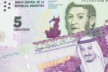 A five peso bill from Argentina, close up in macro with a colorful five riyal bank note from Saudi Arabia