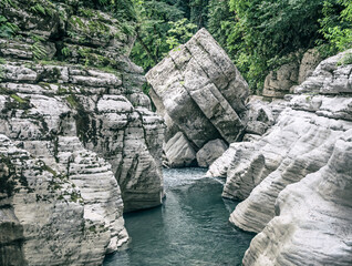 Canyon White Rocks with river water and big stone roadblock in Sochi, Russia