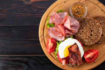ham and egg bacon sandwich on dark wooden background with copy space. Top view. Flat lay