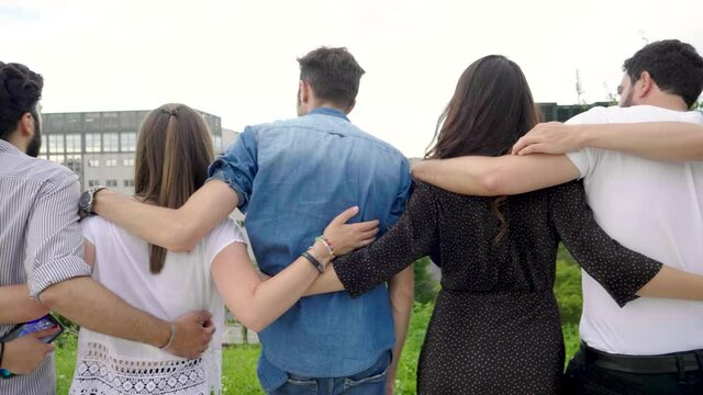 Slow motion shot of group of friends standing in a row in park
