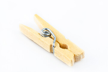 Macro shot of one miniature, wooden clamps lying on a white background.