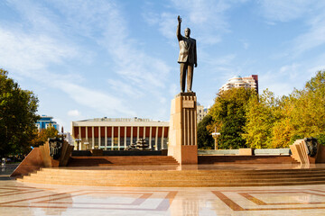 BAKU, AZERBAIJAN - NOVEMBER 14, 2016: Brass statue of the Azerbaijani President Heydar Aliyev, this statue is located in the Heydar Aliyev Square with the palace in the background (Lenin Palace).