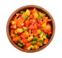 Yellow, red and green peppers Bulgarian. Slicing. Cubes in wooden bowl on white