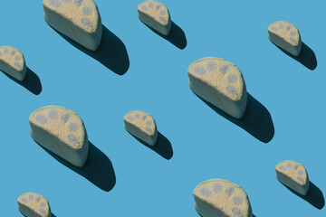 Pattern of tasty marshmallows with hard shadows on a blue background.
