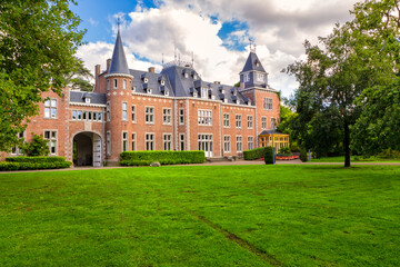 Neo-renaissance castle built in 1898 with big fresh green lawn and trees in front on a cloudy summer day. Bokrijk Genk Flanders Belgium