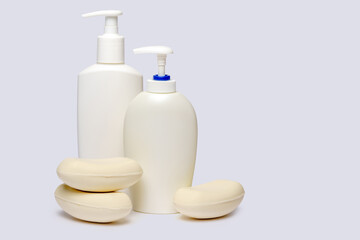 piece of soap and bottle of liquid soap over light grey backgound with clipping path