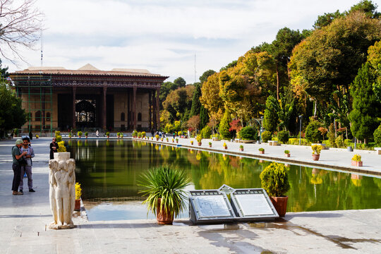 ISFAHAN, IRAN - NOV 18, 2016:  A long pool in front of the ancient Bagh-e Chehel Sotoun - Forty Columns Palace,  Iwan Portal Gate surrounded by trees in the garden