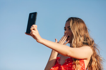 Beautifulgirl makes a selfie outdoors in a summer sunset