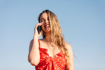 Beautiful blond girl at sunset in countryside speaks at phone