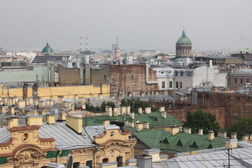 Fototapeta premium Saint-Petersburg, Russia - 10.06.20. Cityscape panorama of old central city part, view from a roof. Famous rooftops of St. Petersburg with Saint Isaac's Cathedralat the background.