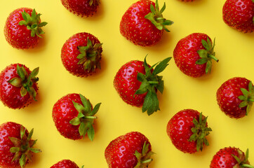 Fototapeta na wymiar pattern a lot of strawberry red ripe on a yellow background