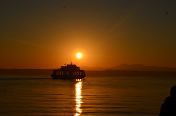 Obraz premium Canakkale with a sunrise and a steamer, morning hours, red colors, sunrise, orange, red, yellow colors 