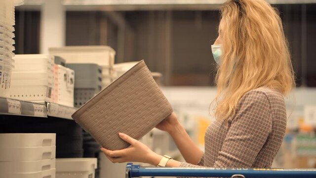 Woman Shopper Choosing Product In Hypermarket Store.Girl In Face Mask Shopping In Market On Covid19 Coronavirus Pandemic Quarantine Lock down. Bayer In Medical Mask In Supermarket Avoid Self Distance