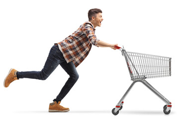 Young man running with an empty shopping cart