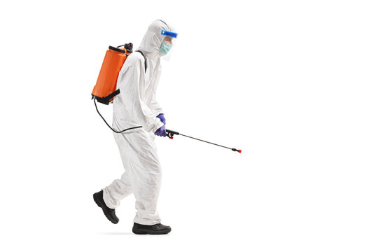 Specialist in a hazmat suit disinfecting with a spraying device