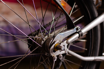 Close up of bicycle wheel and chain with purple background