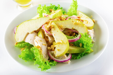 Healthy food. Chicken fillet salad with pear and orange sauce. White background. High key. Selective focus.