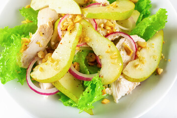 Healthy food. Chicken fillet salad with pear and orange sauce. White background. High key. Selective focus.