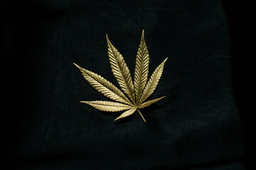 gold cannabis leaf on black background horizontal