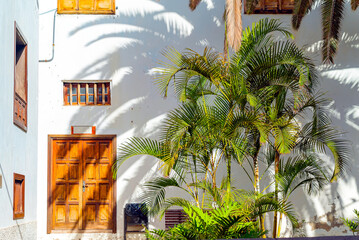 Small spanish patio with palm trees and banch. Old wooden door and windows in Garachico, Tenerife,...
