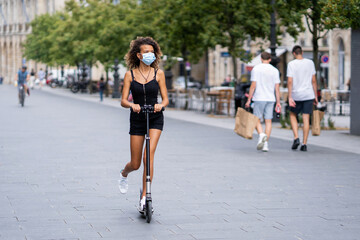 Girl ride on scooter wearing mask to protect from virus